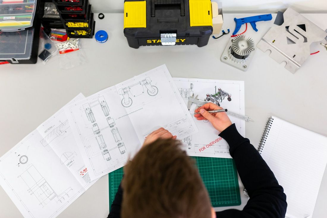 An engineer checking a drawing with a vernier caliper