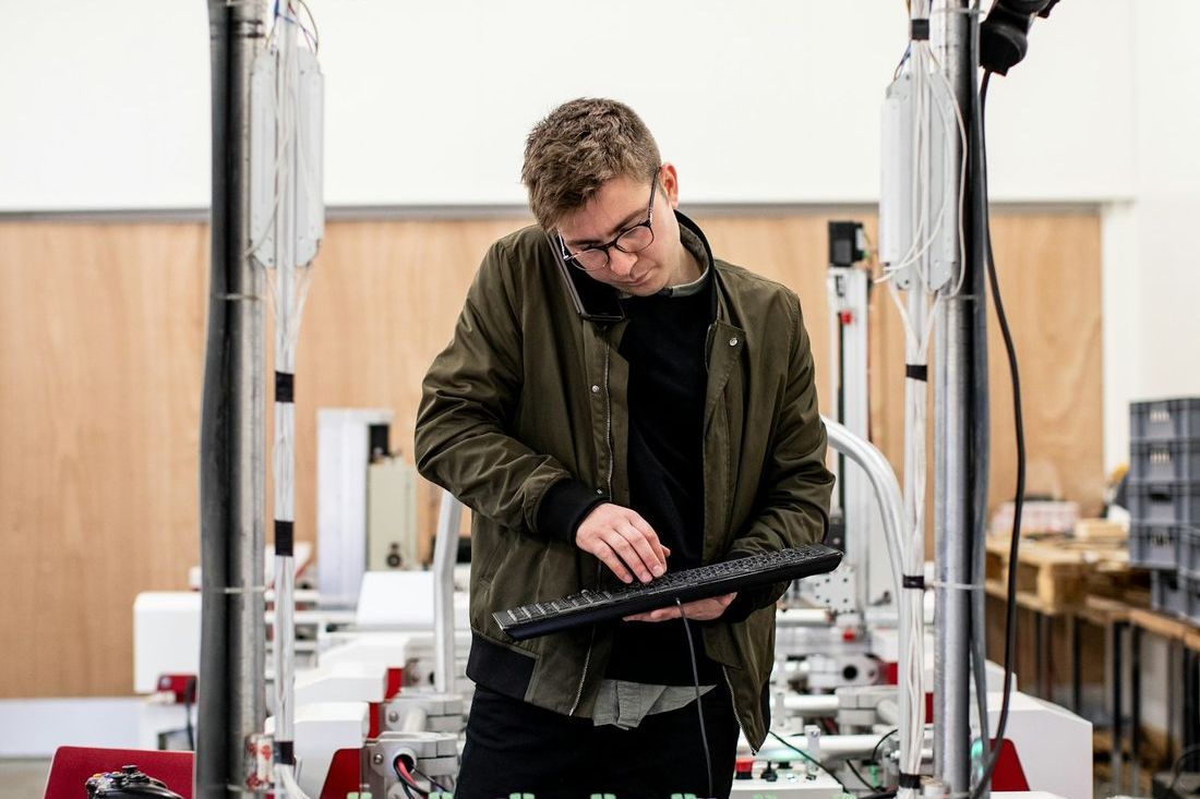 A technician attending to machinery on a production line